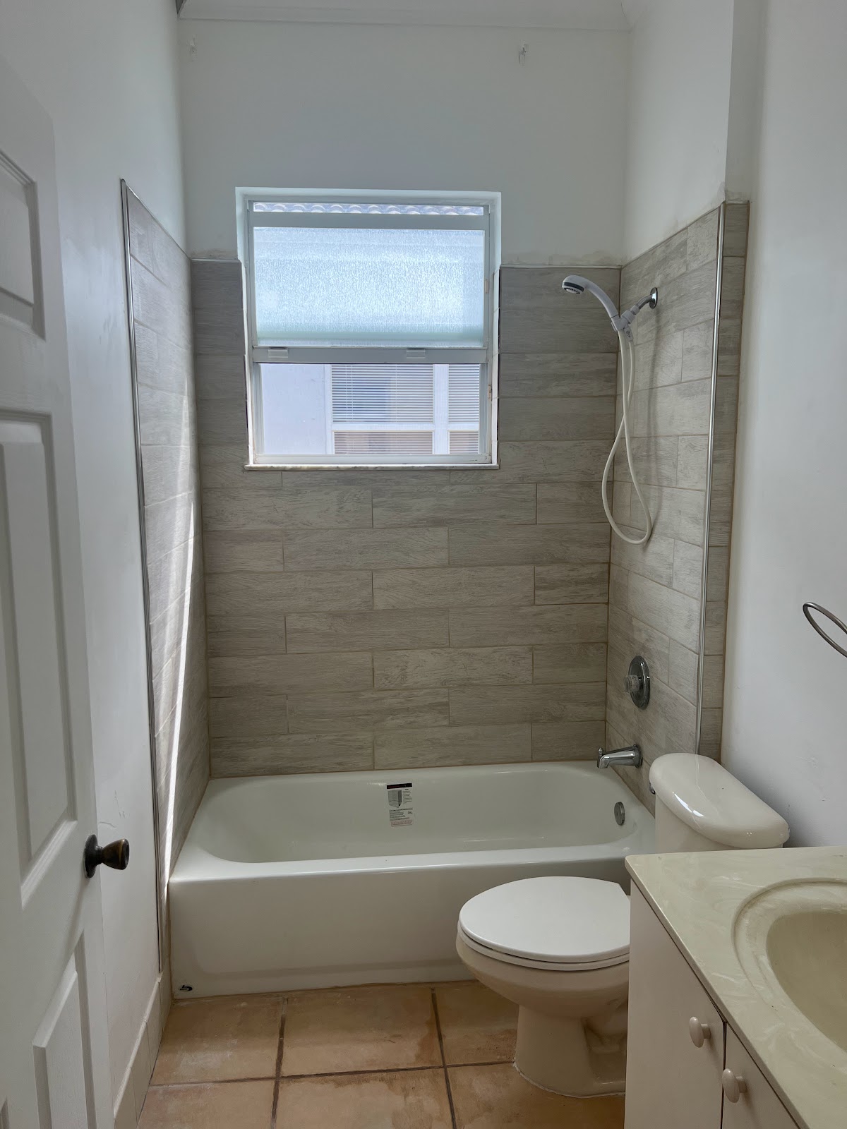 Completed bathroom remodel with wood-look tile and new fixtures